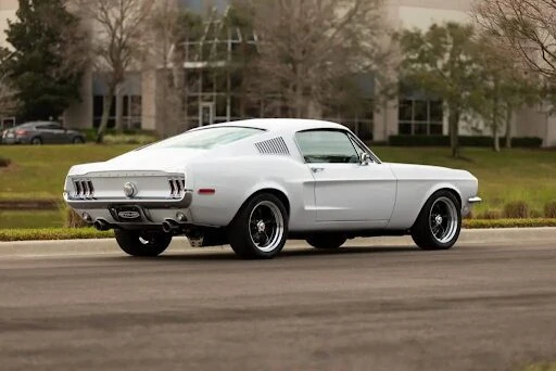 White 1968 Ford Mustang GT Fastback shown in a rear three-quarter view.